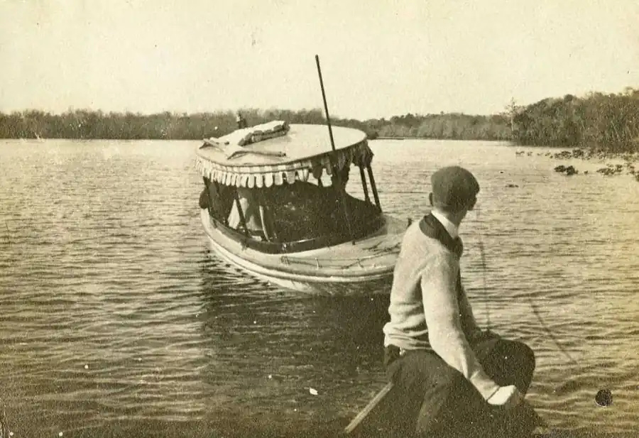 Young man at Lake Beresford with a covered boat